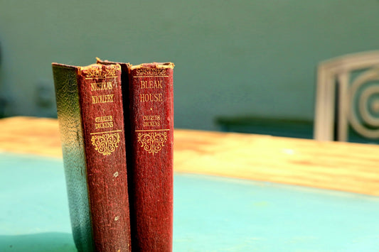 four red hardbound books on brown wooden table