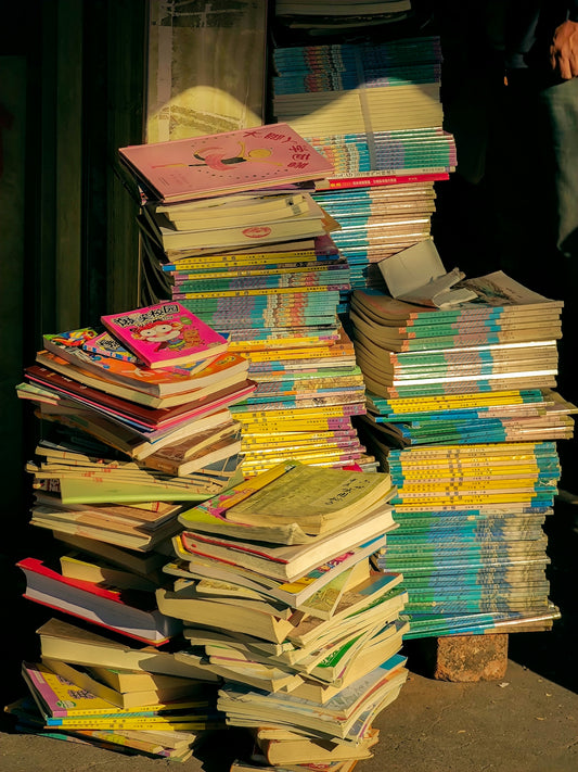 a pile of books sitting on top of a sidewalk