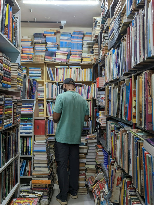 a man standing in a room filled with lots of books
