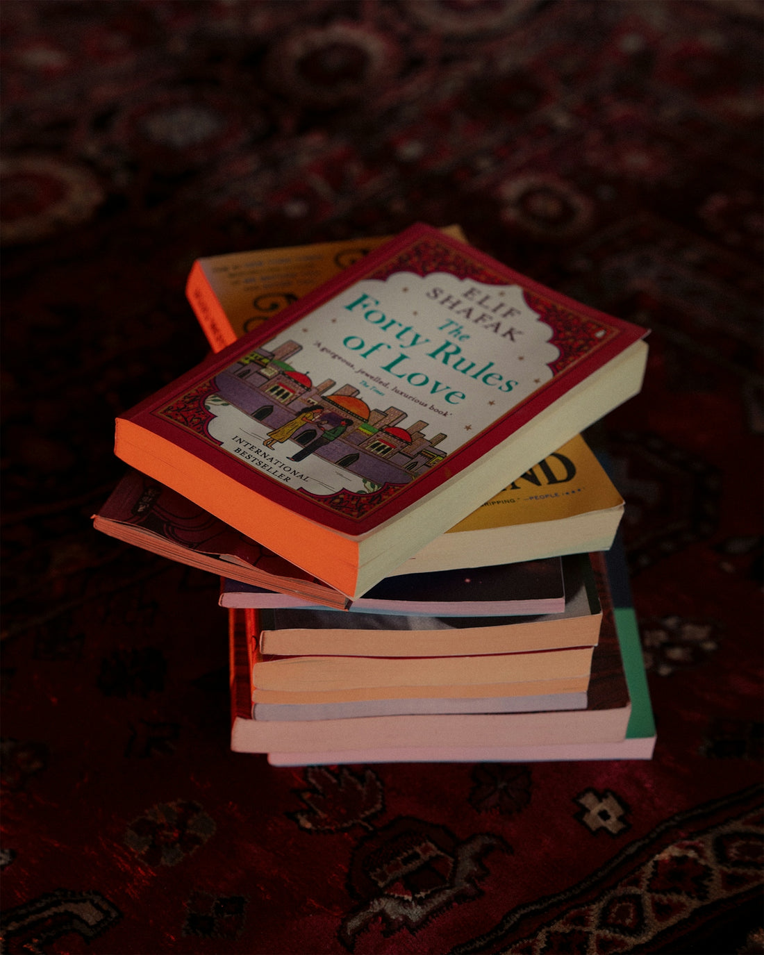 a stack of books sitting on top of a rug