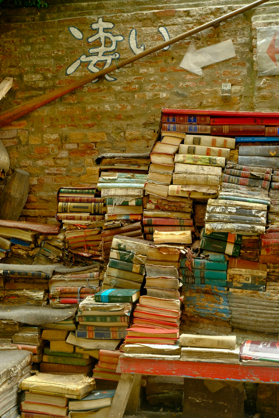 a pile of books sitting on top of a wooden bench
