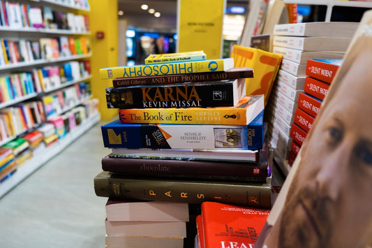 a pile of books sitting on top of a shelf