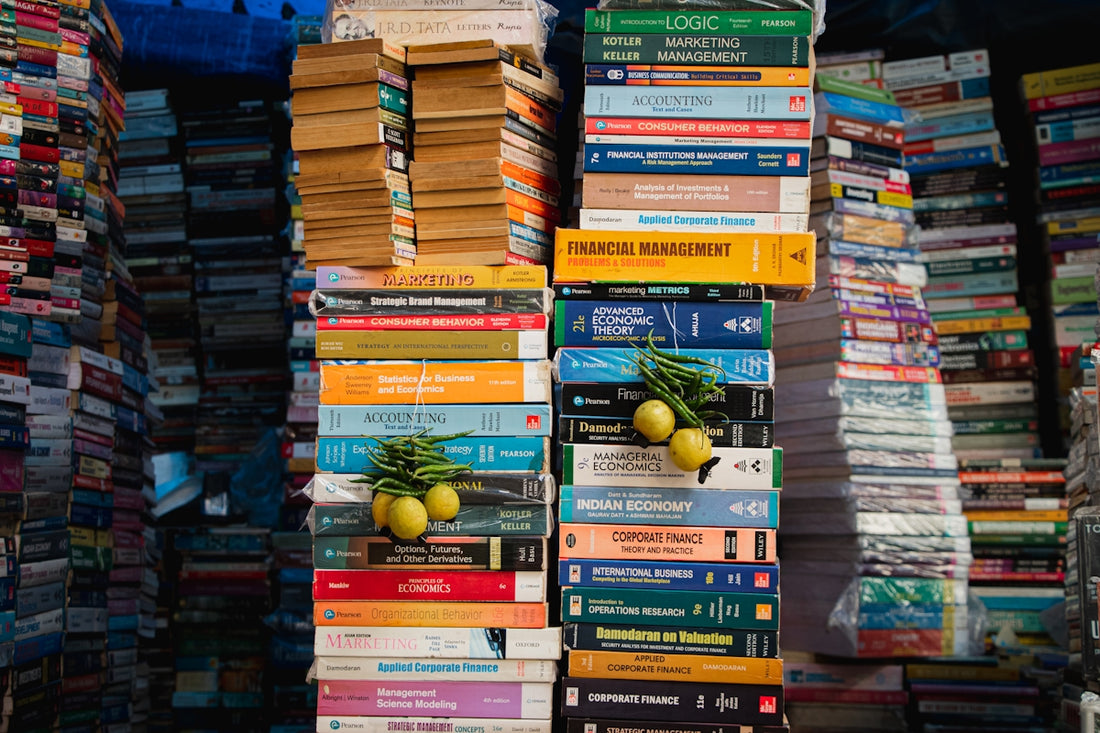 a stack of books with a bunch of fruit on top of them