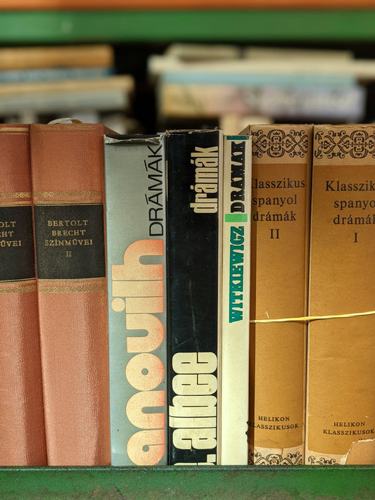 A row of books sitting on top of a green shelf