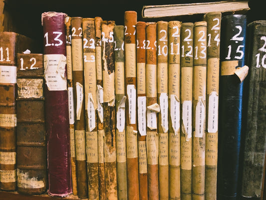 A row of books sitting on top of a wooden shelf