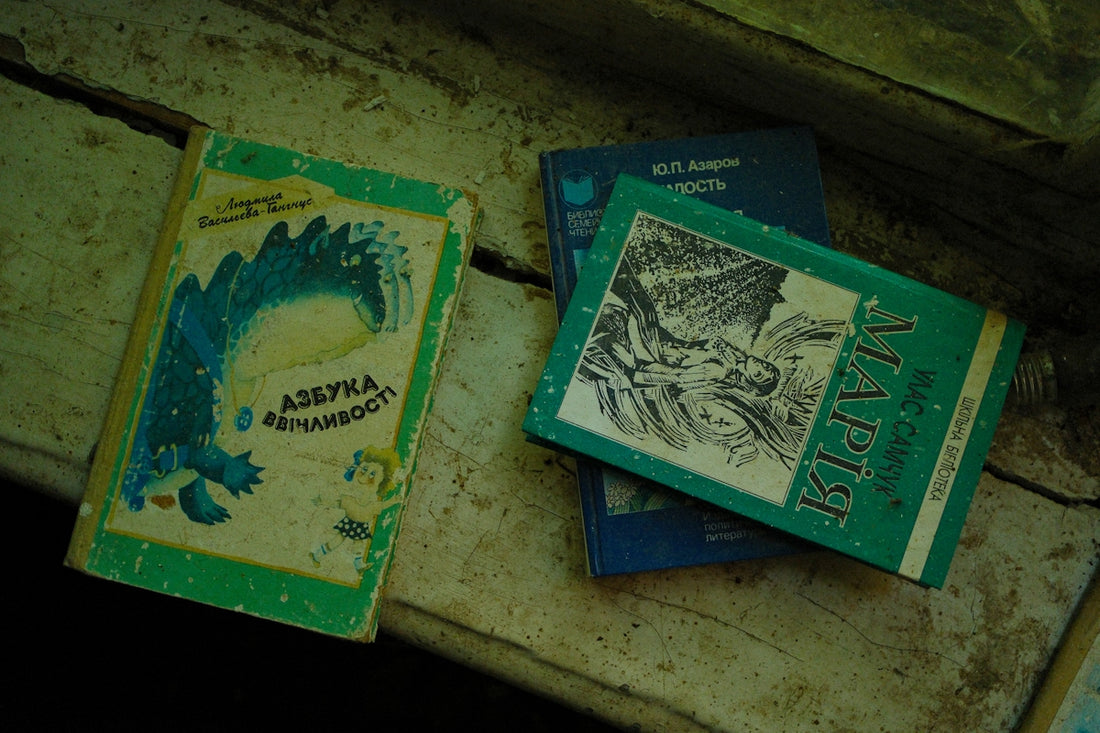 Three old books resting on a wooden surface.